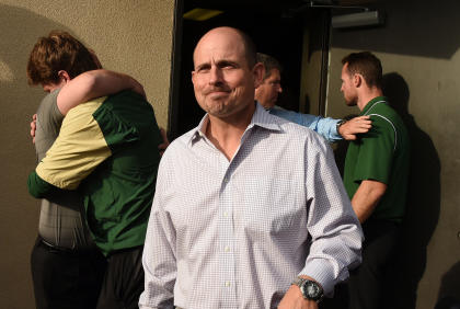 UAB head football coach Bill Clark leaves the meeting with UAB president Ray Watts as players and coaches hug behind him in the doorway, Tuesday, Dec. 2, 2014 in Birmingham, Ala. UAB is shutting down the football program after one of the Blazers&#39; stronger seasons. The university announced the decision Tuesday minutes after President Ray Watts met with the Blazers players and coaches, while several hundred UAB students and fans gathered outside for the third straight day in efforts to support the program. (AP Photo/AL.com, Joe Songer)