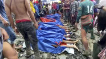 In this image made from video, people gather near the bodies of victims of a landslide near a jade mining area in Hpakant, Kachin state, northern Myanmar Thursday, July 2, 2020. Myanmar government says a landslide at a jade mine has killed dozens of people. (AP Photo/Zaw Moe Htet)