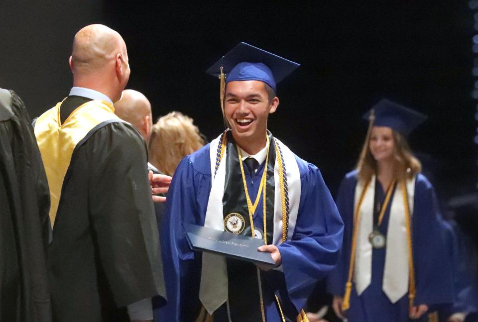 Mainland High School Valedictorian Caden James Allen smiles with diploma in hand, Tuesday, May 24, 2022, during commencement exercises at the Ocean Center.