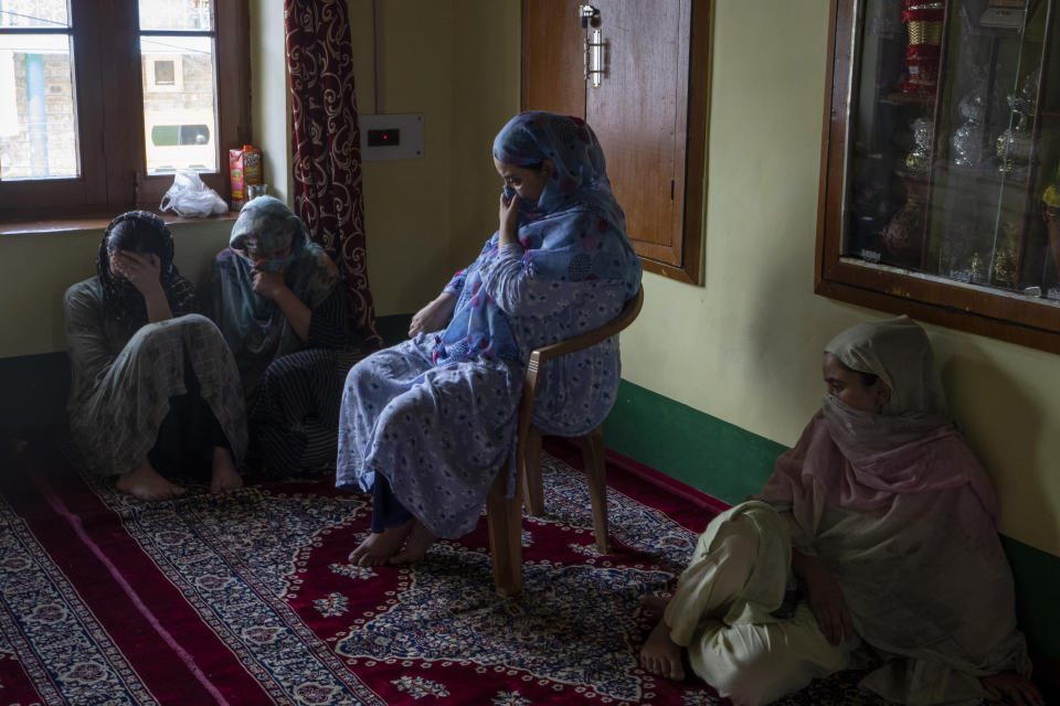 Sehrish Bhat, sitting on a chair, pregnant wife of an Indian army solider Waseem Sarvar Bhat, who was killed in a gunfight with suspected rebels, grieves at her residence in Bandipora, north of Srinagar, Indian controlled Kashmir, Saturday, Aug. 5, 2023. Three Indian soldiers were killed in a gunbattle with rebels fighting against New Delhi's rule in Kashmir, officials said Saturday, as authorities stepped up security on the fourth anniversary since India revoked the disputed region's special status.(AP Photo/Dar Yasin)