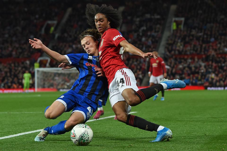 TOPSHOT - Rochdale's English defender Luke Matheson (L) vies with Manchester United's Dutch midfielder Tahith Chong (R) during the English League Cup third round football match between Manchester United and Rochdale at Old Trafford in Manchester, north-west England on September 25, 2019. (Photo by Paul ELLIS / AFP) / RESTRICTED TO EDITORIAL USE. No use with unauthorized audio, video, data, fixture lists, club/league logos or 'live' services. Online in-match use limited to 120 images. An additional 40 images may be used in extra time. No video emulation. Social media in-match use limited to 120 images. An additional 40 images may be used in extra time. No use in betting publications, games or single club/league/player publications. /         (Photo credit should read PAUL ELLIS/AFP/Getty Images)