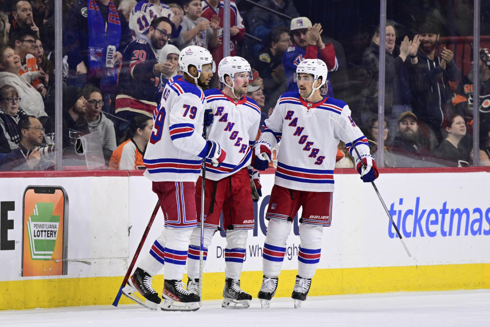New York Rangers' Alexis Lafreniere, center, celebrates his goal with K'Andre Miller (79) and Erik Gustafsson (56) during the second period of an NHL hockey game against the Philadelphia Flyers, Saturday, Feb. 24, 2024, in Philadelphia. (AP Photo/Derik Hamilton)
