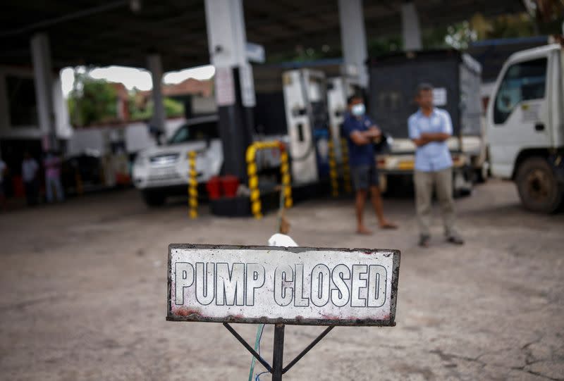People wait in a queue to buy petrol at a closed fuel station, amid the country's economic crisis in Colombo