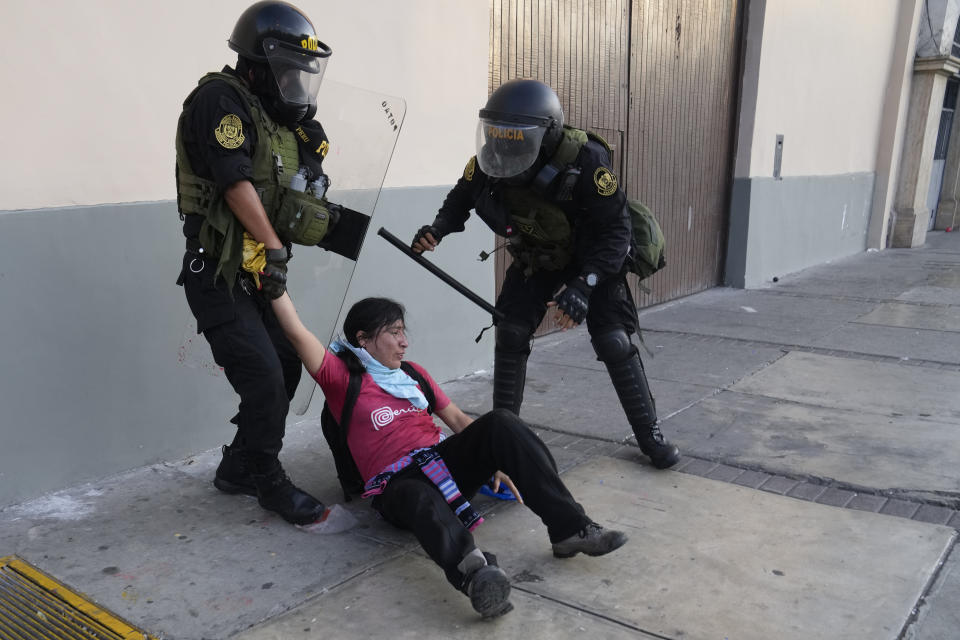 Police detain an anti-government protester in Lima, Peru, Tuesday, Jan. 24, 2023. Protesters are seeking the resignation of President Dina Boluarte, the release from prison of ousted President Pedro Castillo, immediate elections and justice for demonstrators. (AP Photo/Martin Mejia)