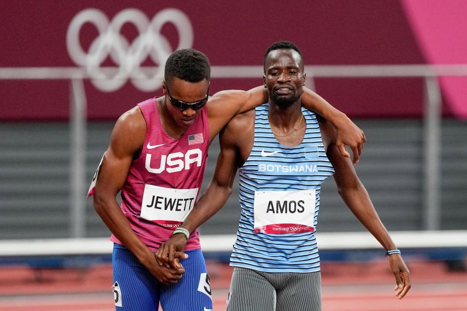 The USA's Isaiah Jewett, left, and Botswana's Nijel Amos, right, shake hands after falling in the men's 800-meter semifinal at the Tokyo Olympics.