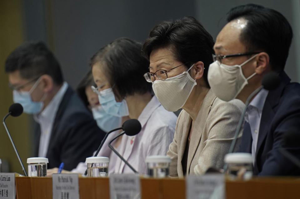 Hong Kong Chief Executive Carrie Lam, second from right, listens to reporters questions during a press conference held in Hong Kong, Sunday, July 19, 2020. Lam introduced renewed anti-virus measures Sunday, saying the southern Chinese city's situation is "really critical" and adding that she sees "no sign" that it's under control. The new restrictions make mask wearing mandatory in any public place including inside buildings, and put non-essential civil servants back to work at home. (AP Photo/Vincent Yu)