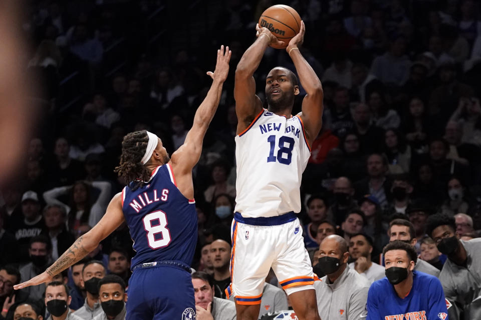 New York Knicks guard Alec Burks (18) shoots a 3-point basket over Brooklyn Nets guard Patty Mills (8) during the first half of an NBA basketball game, Tuesday, Nov. 30, 2021, in New York. (AP Photo/Mary Altaffer)