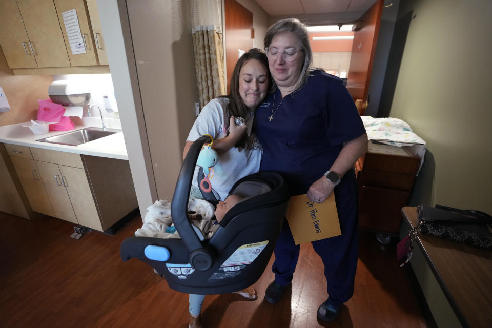 Katie O'Brien, left, hugs Dr. Pam Evans, an obstetrician, after O'Brien gave pictures of O'Brien's son whom Evans delivered as O'Brien visits the maternity ward at the Henry County Medical Center in Paris, Tenn., on Tuesday, Aug. 29, 2023. With the closing of the maternity ward at the facility in early September, Evans fears that things like preterm deliveries, infant mortality and low-birthweight babies — a measure in which the county already ranks poorly — are bound to get worse. (AP Photo/Mark Humphrey)