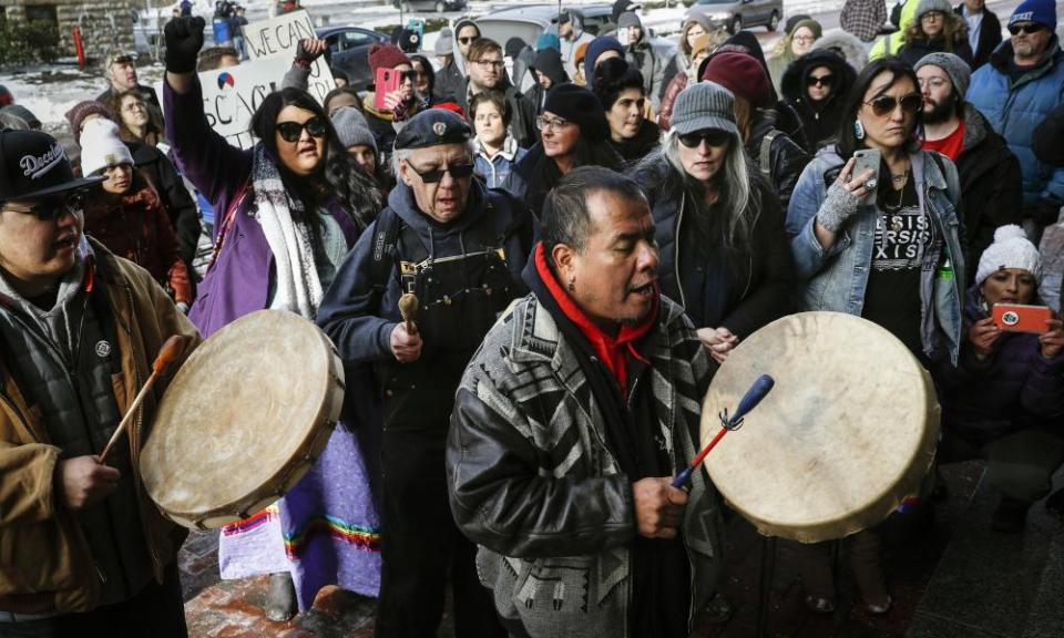 A protester leads a Native American prayer with a traditional drum outside the Catholic diocese of Covington on Tuesday in Covington, Kentucky.