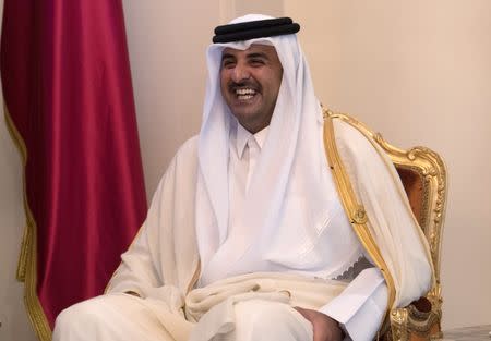 Sheikh Tamim bin Hamad Al Thani, the Emir of Qatar smiles as he speaks to Britain's Prime Minister Theresa May during a bilateral meeting at the Gulf Cooperation Council summit, in Manama, Bahrain, December 7, 2016. REUTERS/Carl Court/Pool