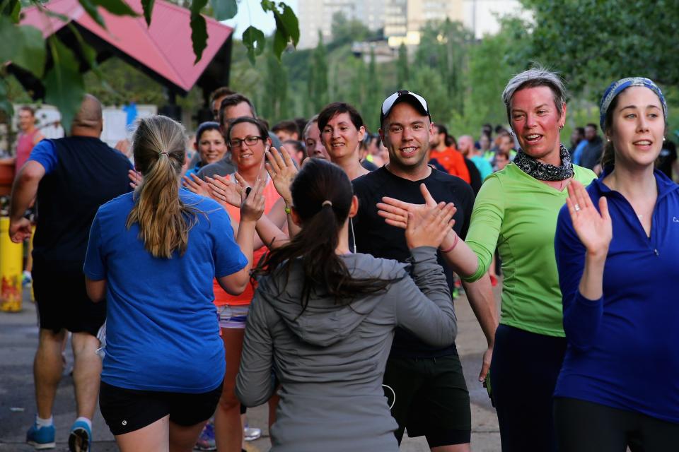 EDMONTON, AB - JUNE 12:  Runners high five during a November Project workout at Louise McKinney Riverfront Park on June 12, 2015 in Edmonton 