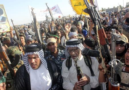 Shi'ite volunteers, who have joined the Iraqi army to fight against the predominantly Sunni militants from the radical Islamic State of Iraq and the Levant (ISIL), take part in a parade on a street in Kanaan, Diyala province, June 26, 2014. REUTERS/Stringer