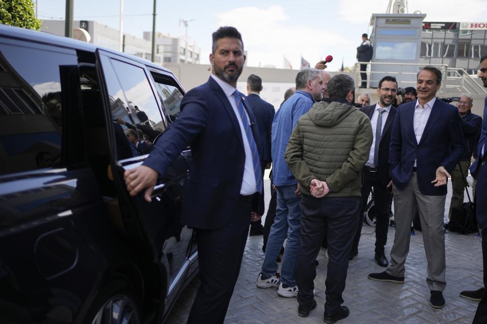 Greece's Prime Minister and New Democracy leader Kyriakos Mitsotakis, right, speaks with journalists as he leaves the headquarters of his party, during the election campaign in northern Athens, Greece, Friday, April 28, 2023. (AP Photo/Thanassis Stavrakis)