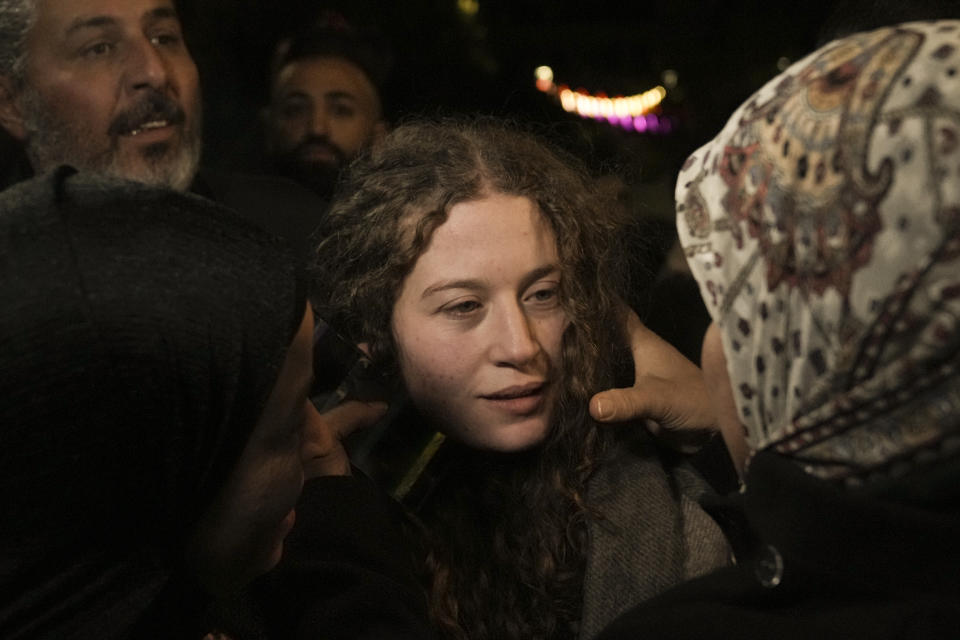 Palestinian activist Ahed Tamimi, center is hugged by a woman after she was released from prison by Israel, in the West Bank town of Ramallah, early Thursday, Nov. 30, 2023. International mediators on Wednesday worked to extend the truce in Gaza, encouraging Hamas militants to keep freeing hostages in exchange for the release of Palestinian prisoners and further relief from Israel's air and ground offensive. (AP Photo/Nasser Nasser)