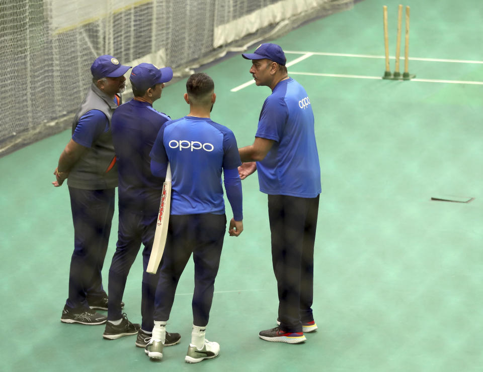 India's captain Virat Kohli, second right, listens to team coach Ravi Shastri, right, as he interacts with bowling coach Bharat Arun, left, and batting coach Sanjay Bangar during an indoor training session ahead of their Cricket World Cup match against West Indies at Old Trafford in Manchester, England, Tuesday, June 25, 2019. (AP Photo/Aijaz Rahi)