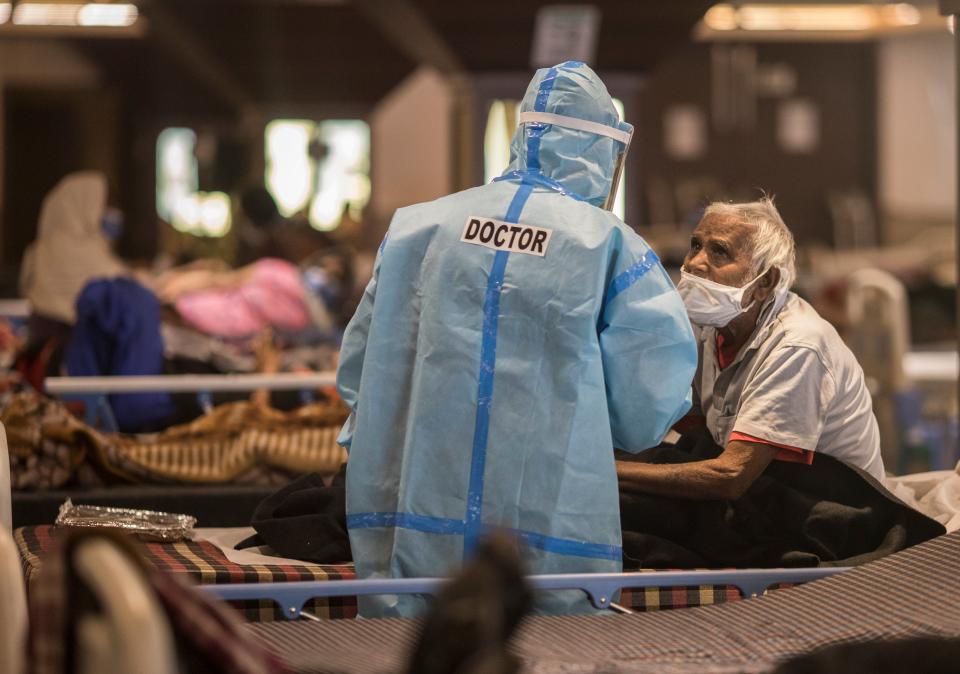 <p>A doctor is seen talking to a patient who was tested positive and was in quarantine at a quarantine centre for Covid-19 coronavirus infected patients at a banquet hall that was converted into an isolation centre to handle the rising cases of infection on 15 April in New Delhi</p> (Getty Images)