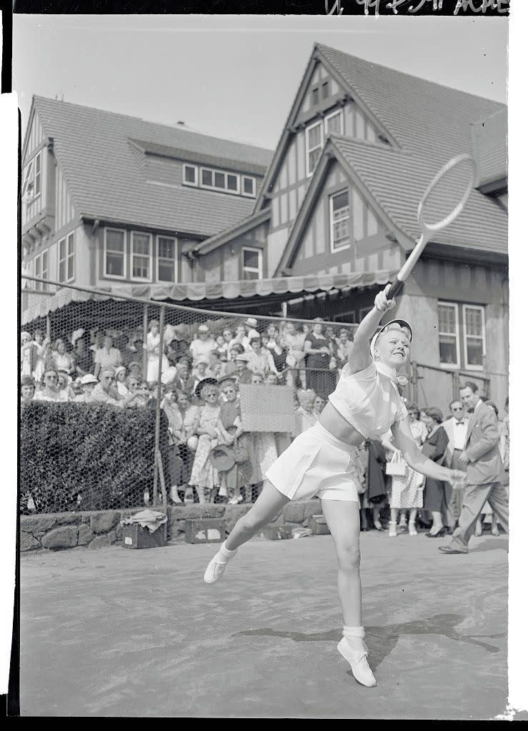 <p>Ginger Rogers hits the tennis court to practice for an upcoming mixed doubles match during the National Tennis Open Meet in 1950. </p>
