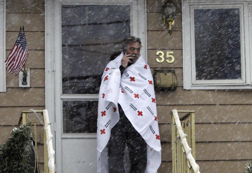 Ben Colontonio talks on his cell phone wrapped in a blanket donated by the American Red Cross as a Nor'easter approaches in the wake of Superstorm Sandy, Wednesday, Nov. 7, 2012, in Little Ferry, N.J. (AP Photo/Kathy Willens)