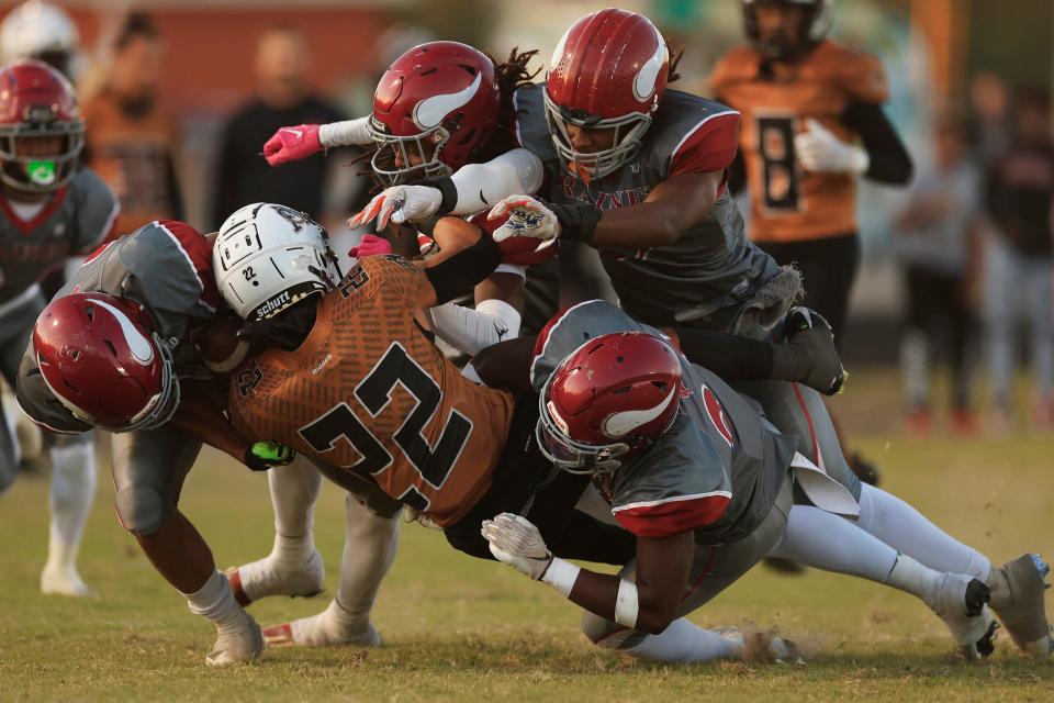 Atlantic Coast's Jorge Schaible (22) is stopped by the Raines defense during the first quarter of a regular season football matchup Friday, Oct. 21, 2022 at Atlantic Coast High School in Jacksonville. The Raines Vikings blanked the Atlantic Coast Stingrays 36-0.