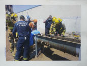 This 2015 photo shows first responders as they work to free Blas Sanchez from an auger that snagged and mutilated his right leg, at Hickman's Family Farms, in Tonopah, Ariz. Nationwide, prisoners are increasingly being placed in dangerous jobs, sometimes with little or no training. They are part of a labor system that, often by design, largely denies them basic rights and protections guaranteed to other American workers. (Provided by Blas Sanchez via AP)