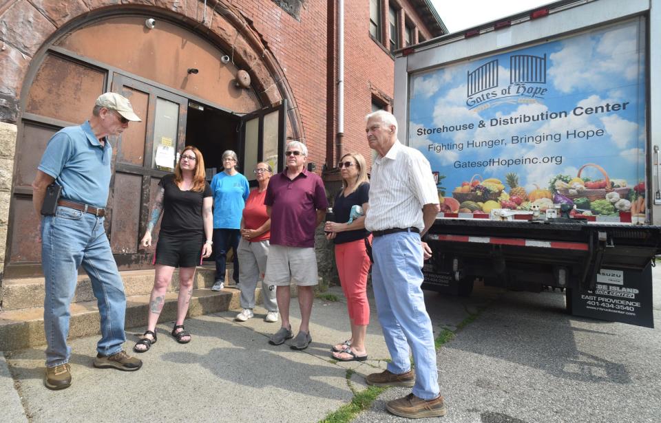 Gates of Hope volunteers Wayne Cahoon, Faith Bon Jovi, Tracy Saulnier, Priscilla Andrade, Paul and Caroline Baluch and Bill Horner talk about the food pantry that operates out of the former Davol School.