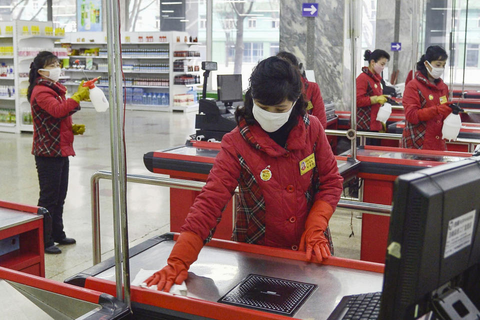 Trabajadoras de un supermercado desinfectan las cajas ante la creciente preocupación por el brote de un coronavirus, en Pyongyang, Corea del Norte, el 28 de febrero de 2020. (Kyodo News via AP)