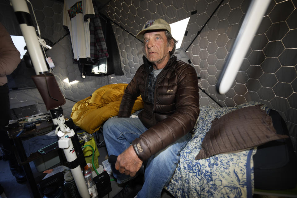 Gary Peters sits in his tent at the east safe outdoor space in the parking lot of the city of Denver Human Service building in Denver on Thursday, Feb. 17, 2022. The safe space is home to more than 150 people. (AP Photo/David Zalubowski)