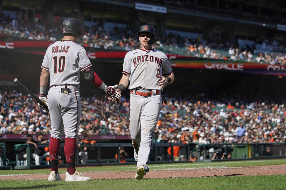 Arizona Diamondbacks' Jordan Luplow (8) celebrates with Josh Rojas (10) after scoring against the San Francisco Giants on a double by Christian Walker during the seventh inning of a baseball game in San Francisco, Saturday, Oct. 1, 2022. (AP Photo/Godofredo A. Vásquez)