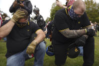 Members of the Proud Boys and other right-wing demonstrators kneel in prayer at a rally on Saturday, Sept. 26, 2020, in Portland, Ore. (AP Photo/Allison Dinner)