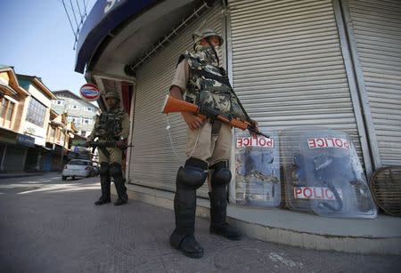 Central Reserve Police Force (CRPF) personnel stand guard in front of closed shops during a strike in Srinagar June 17, 2015. REUTERS/Danish Ismail