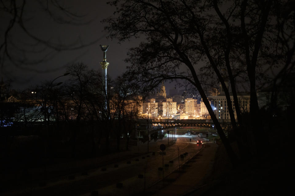 A police officer patrols the empty streets near Independence Square (Maidan) just minutes after midnight, during curfew in Kyiv, Ukraine, Sunday, Jan. 1, 2023. Half an hour into the new year, air raid sirens rang in the capital. (AP Photo/Felipe Dana)