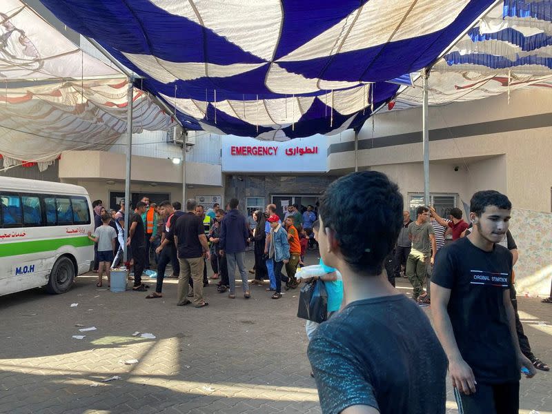 People, including Palestinian children, who fled their house due to Israeli strikes, gather at Al Shifa hospital where they shelter