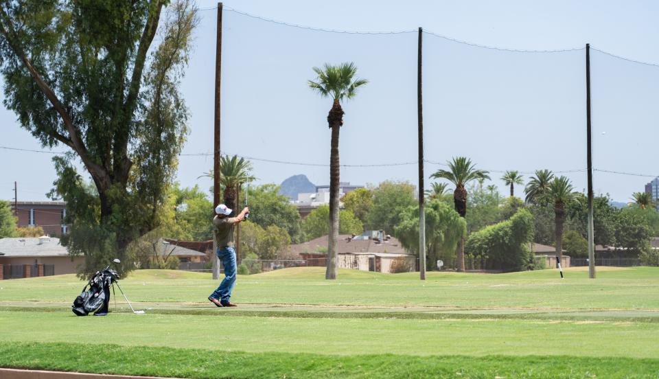 A golfer swings at the driving range at the Encanto Golf Course in Phoenix on Wednesday, July 24, 2024. Despite warm temperatures, several golfers came out to play.