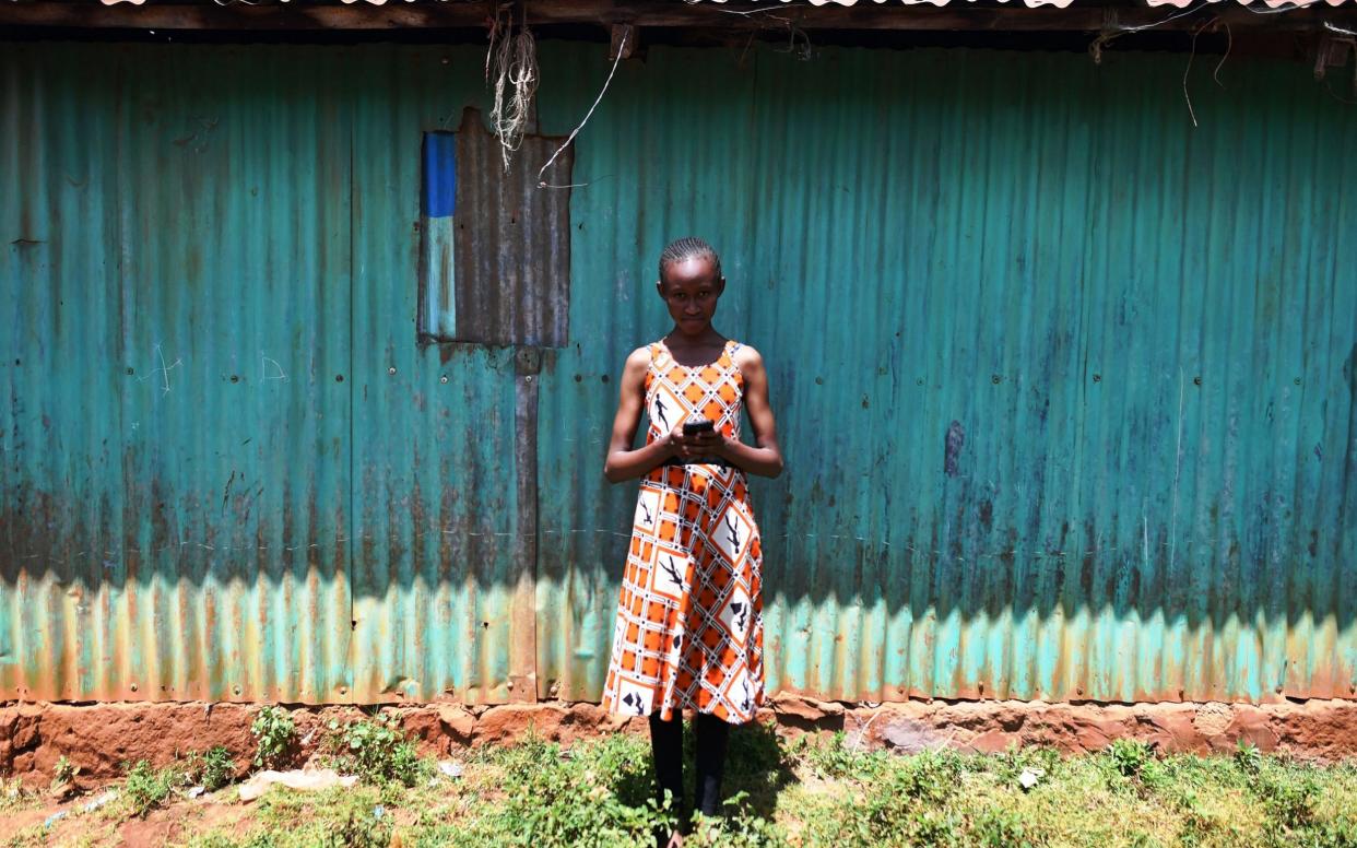 A young girl using a smartphone in Nairobi, Kenya. - AFP