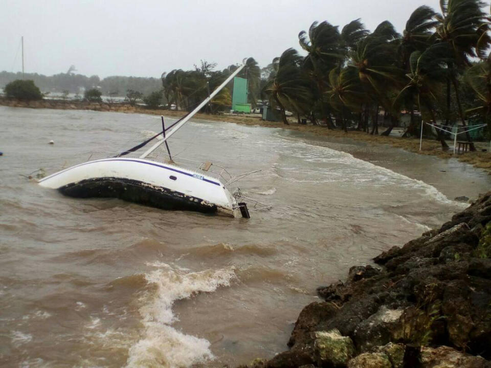 <p>A boat lays on its side off the shore of Sainte-Anne on the French Caribbean island of Guadeloupe, early Tuesday, Sept. 19, 2017, after the passing of Hurricane Maria. (Photo: Dominique Chomereau-Lamotte/AP) </p>