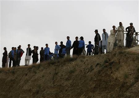 People stand near the site of a suicide attack in Kabul May 26, 2014. REUTERS/Omar Sobhani