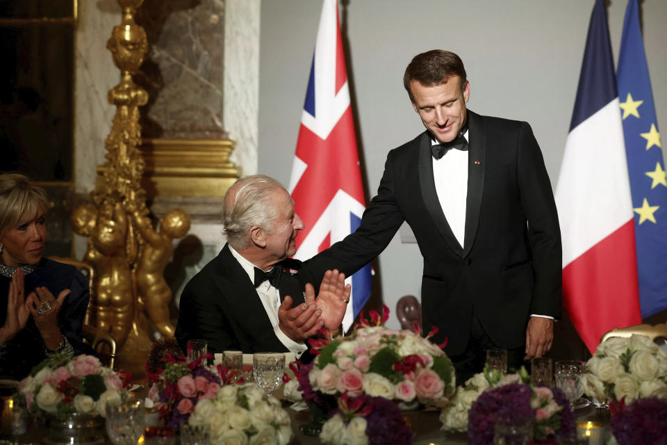 Britain's King Charles III applauds with Brigitte Macron as French President Emmanuel Macron looks down during a state dinner in the Hall of Mirrors at the Chateau de Versailles, in Versailles, west of Paris, Wednesday, Sept. 20, 2023. President Emmanuel Macron and King Charles III held talks in Paris on Wednesday at the start of a long-awaited three-day state visit meant to highlight the friendship between France and the U.K. (Benoit Tessier/Pool via AP)