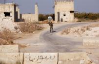 A Syrian army soldier walks in the town of Morek, Hama district