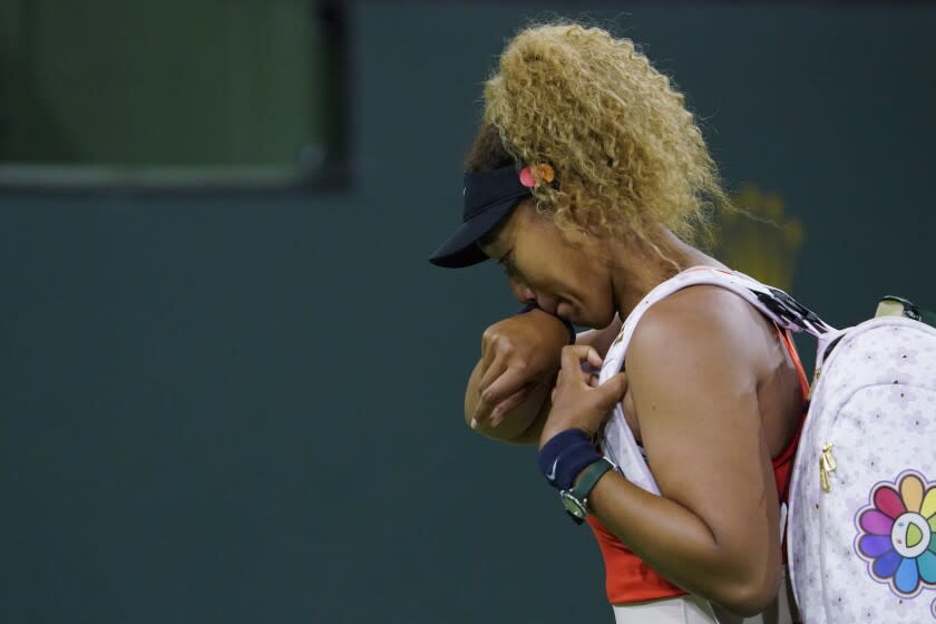 Naomi Osaka, of Japan, wipes away tears as she leaves the court after losing her match to Veronika Kudermetova, of Russia, at the BNP Paribas Open tennis tournament Saturday, March 12, 2022, in Indian Wells, Calif. (AP Photo/Mark J. Terrill)