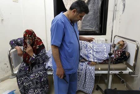 FILE PHOTO: Women, affected by what activists say was a gas attack, receive treatment inside a makeshift hospital in Kfar Zeita village in the central province of Hama May 22, 2014. REUTERS/Badi Khlif