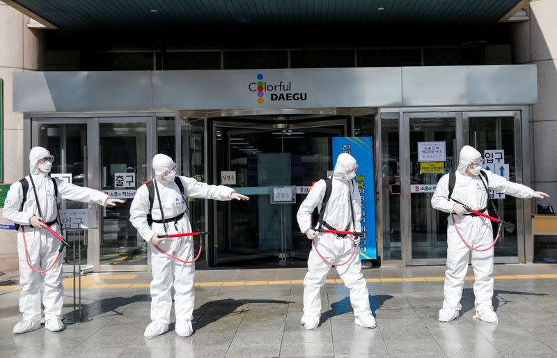 South Korean soldiers wearing protective gear prepare to sanitize a street in front of the city hall after the rapid rise in confirmed cases of the novel coronavirus disease of COVID-19 in Daegu