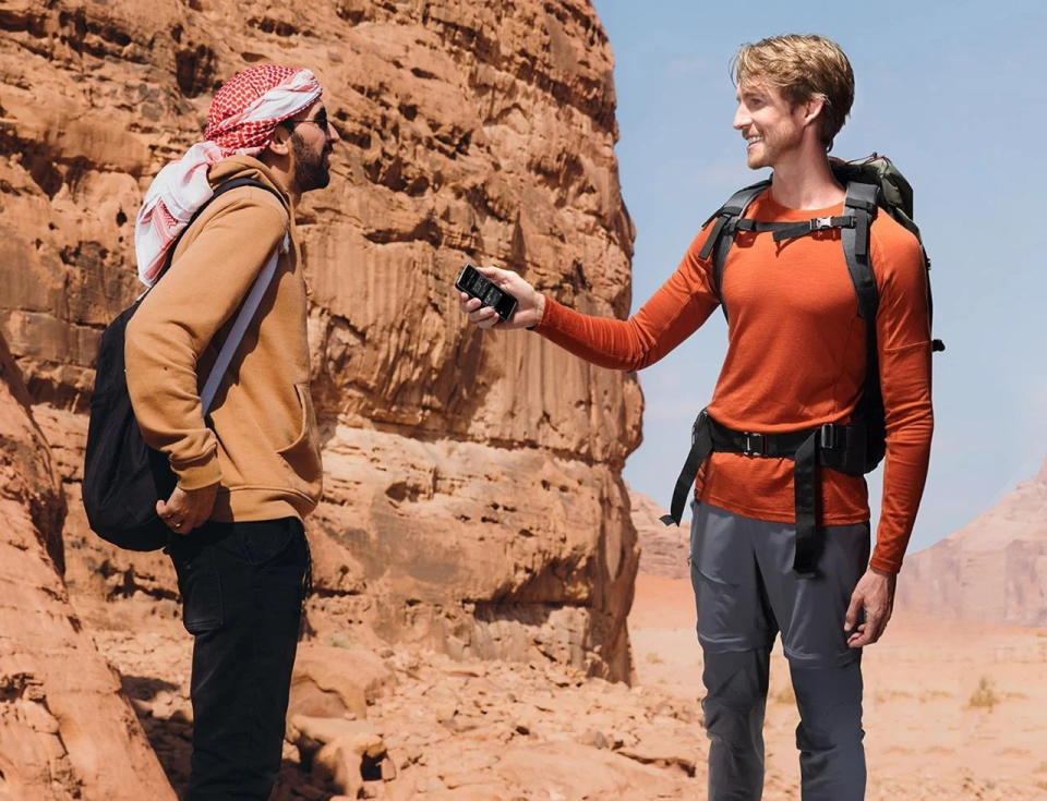 Tourist uses the Fluentalk T1 to converse with a local in real time while on the go.