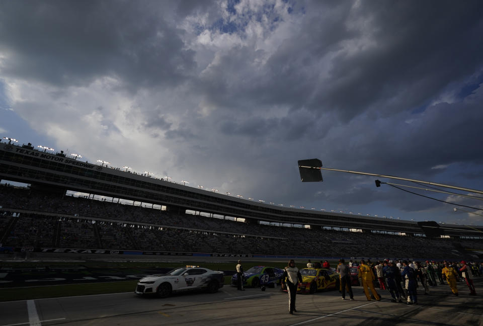 With clouds threatening lightning, a NASCAR Cup Series auto race field sits under a red flag delay at Texas Motor Speedway in Fort Worth, Texas, Sunday, Sept. 25, 2022. (AP Photo/LM Otero)