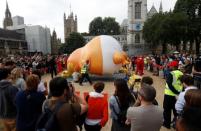 Demonstrators inflate a blimp portraying U.S. President Donald Trump, in Parliament Square, during the visit by Trump and First Lady Melania Trump in London, Britain July 13, 2018. REUTERS/Peter Nicholls
