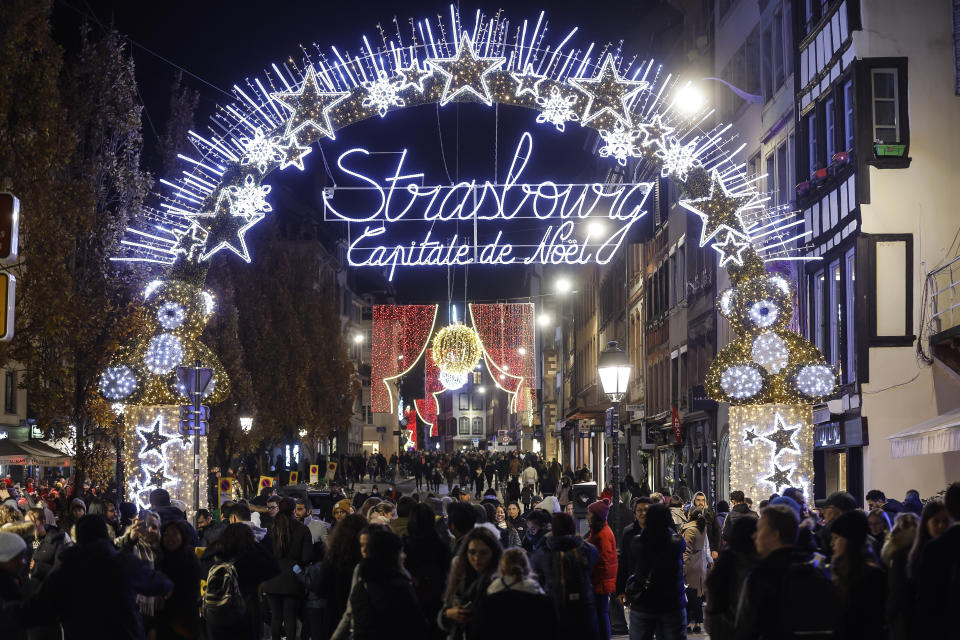 FILE - Visitors stroll around Strasbourg's Christmas market, one of the oldest and biggest Christmas markets in Europe. Strasbourg, eastern France, Nov. 25, 2022. In cities across Europe, officials are wrestling with a choice this Christmas. Dim lighting plans to send a message of energy conservation and solidarity with citizens squeezed by both higher energy costs and inflation or let the lights blaze in a message of defiance after two years of pandemic-suppressed Christmas seasons, creating a mood that retailers hope loosen holiday purses. (AP Photo/Jean-Francois Badias, File)