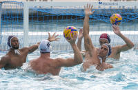 U.S. Olympic Water Polo Team attacker Max Irving, far left, trains for the Paris Olympics at Mt. San Antonio College in Walnut, Calif., on Wednesday, Jan. 17, 2024. Irving's father, Michael Irving, is a Pac-12 college basketball referee. Max Irving is also the only Black man on the U.S. Olympic Water Polo Team and a prominent advocate for diversity in the sport. (AP Photo/Damian Dovarganes)