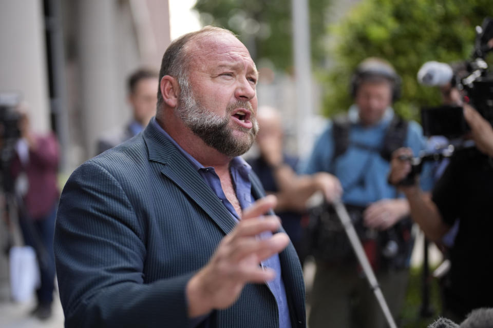 FILE - Right-wing conspiracy theorist Alex Jones speaks to the media after arriving at the federal courthouse for a hearing in front of a bankruptcy judge, Friday, June 14, 2024, in Houston. A federal bankruptcy judge Thursday, June 27, stopped an effort by the parents of a boy killed in the Sandy Hook Elementary School shooting to collect on some of the $50 million owed to them by Jones and his company for his claims that the massacre was a hoax. (AP Photo/David J. Phillip, File)