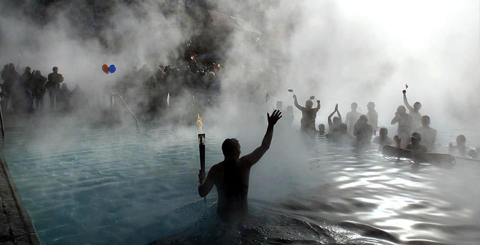 George DiCarlo waves to the crowd gathered at the end of his leg of the Olympic torch relay at Glenwood Springs hot springs pool on Feb. 2, 2002. | Scott G Winterton, Deseret News