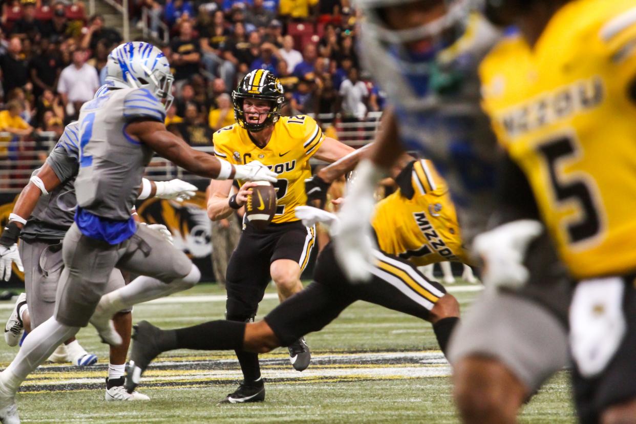 Missouri quarterback Brady Cook (12) evades pressure from Memphis defenders during MU's game against Memphis at the Dome at America's Center on Sept. 23, 2023, in St. Louis, Mo.