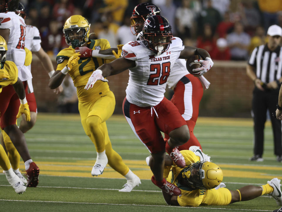 Texas Tech running back Tahj Brooks (28) slips past Baylor linebacker Josh White, bottom right, in the first half of an NCAA college football game, Saturday, Oct. 7, 2023, in Waco, Texas. (Rod Aydelotte/Waco Tribune-Herald, via AP)